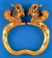 A pair of gold armlets with terminals in the shape of horned griffins